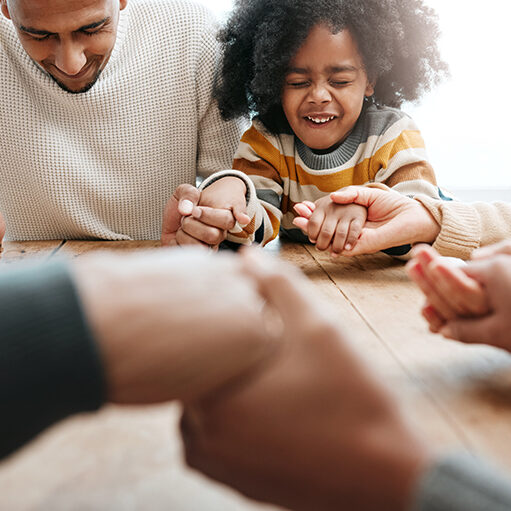 Praying, together and family holding hands for worship, support and church service. Happy, hope and a father, child and people with prayer, faith and belief in religion, grateful and praising.